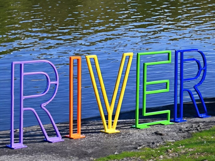 Letter Bike Racks spelling RIVER in front of a river