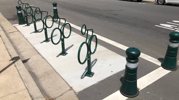 Bollards are a more secure, but more permanent, solution to delineating a bicycle corral.  