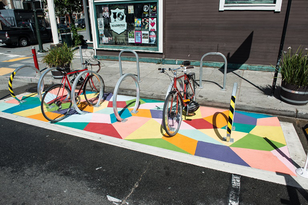 On-street bicycle parking that has been painted with bright colors and is highly visible.